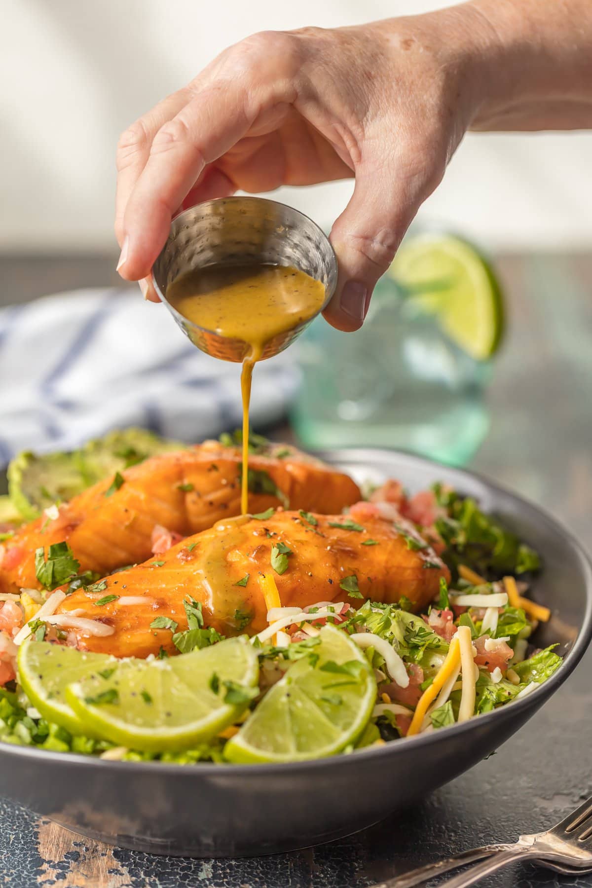 This TEQUILA LIME SALMON SALAD is the perfect hearty and delicious salad for any occasion! Salmon topped with a spicy tequila lime marinade and laid atop a bed of lettuce, corn, beans, avocado, pico, and more! SO MUCH FLAVOR!